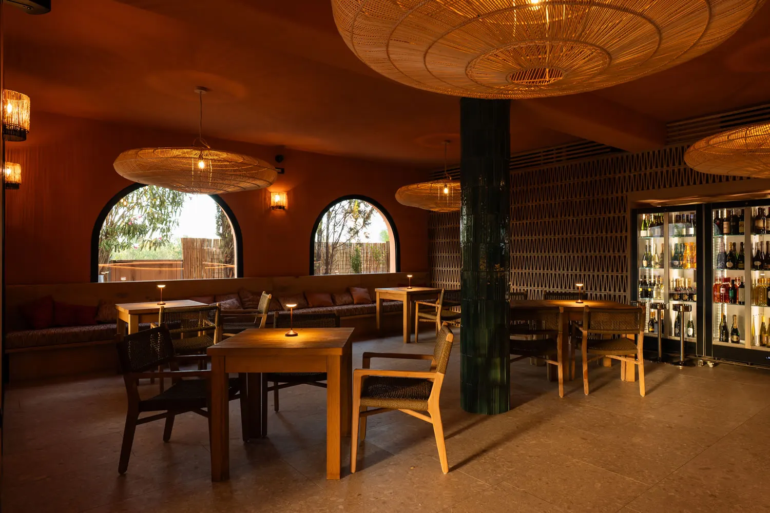 La sala di Jaga con archi, lampade in vimini e la cantina dei vini illuminata