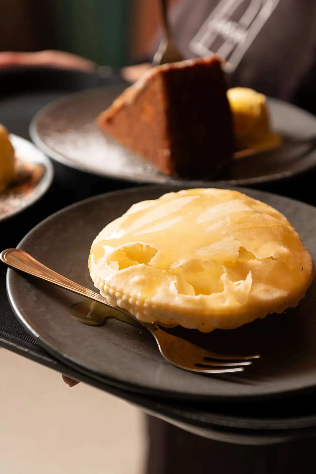 Dolce al piatto, con la torta al cioccolato sullo sfondo