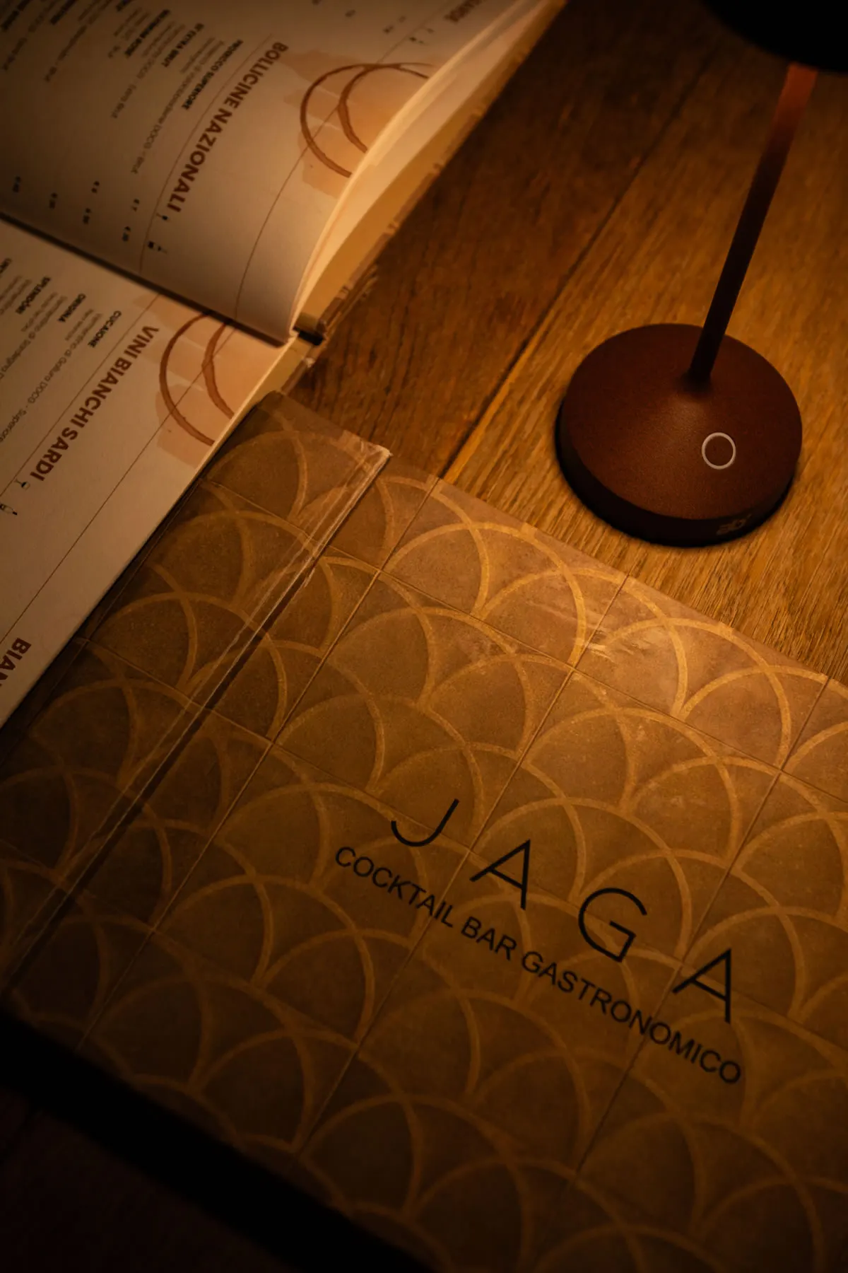 La copertina del menù con la trama di archi, sotto la lampada