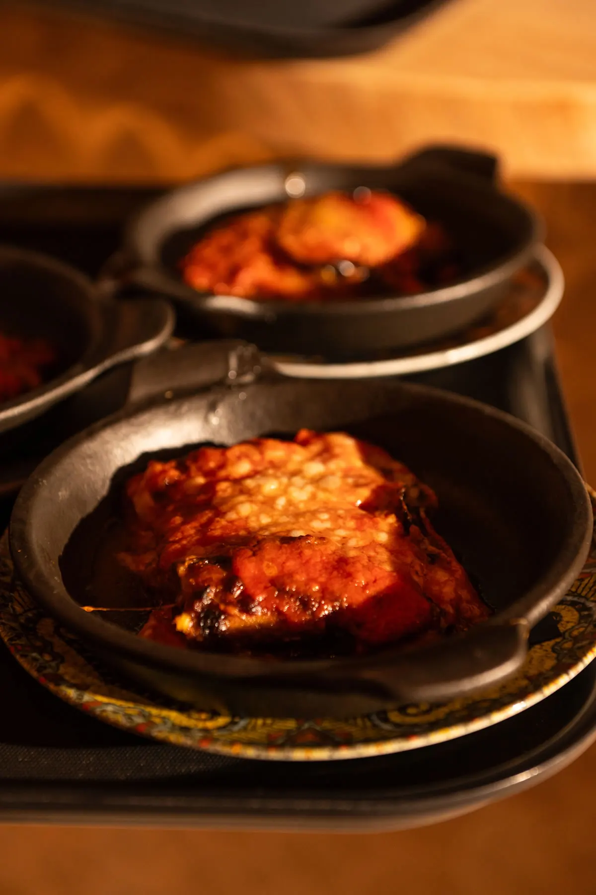 Frittura con salsa sul piatto scuro, nella luce calda